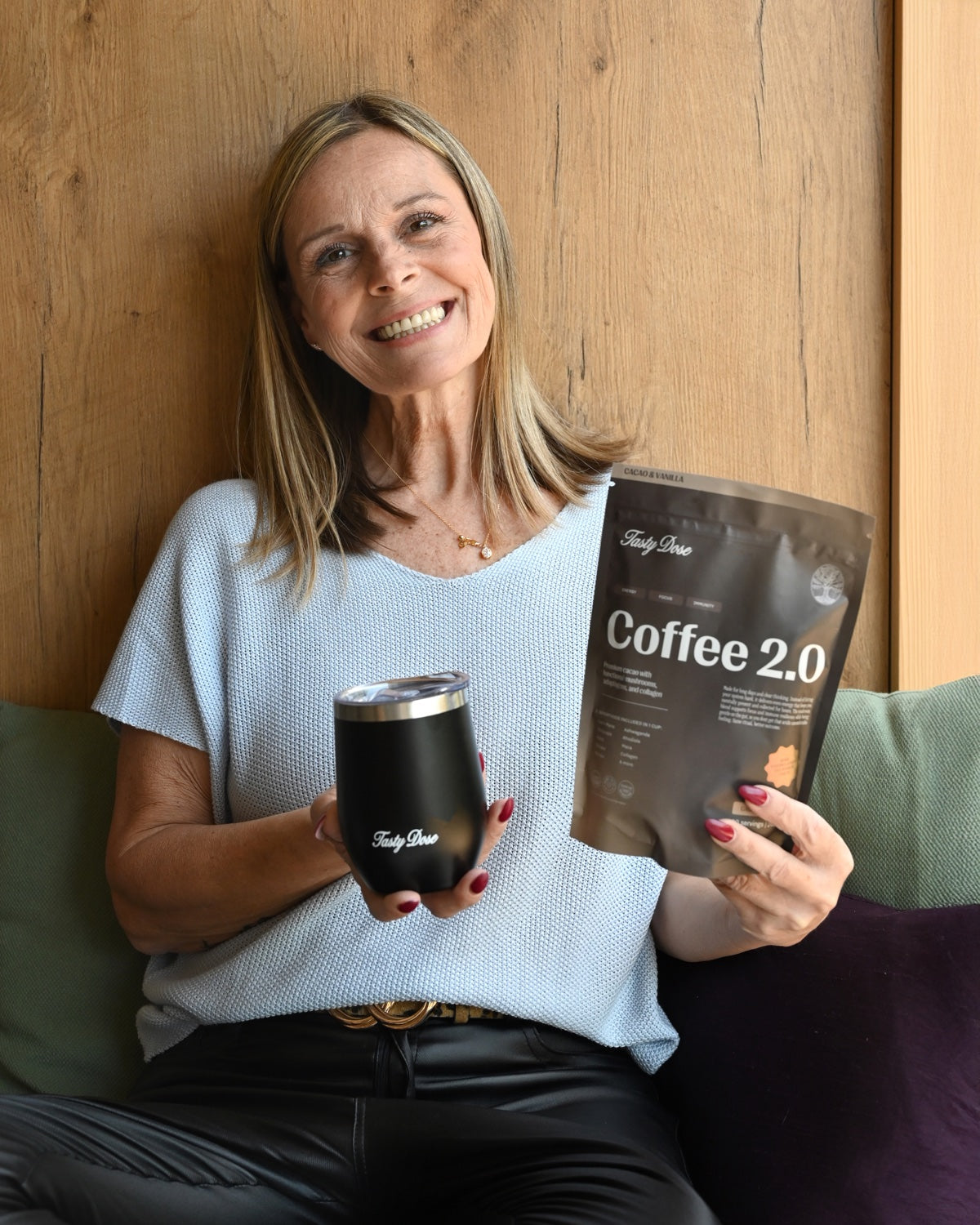 Real Tasty Dose customer smiling with their Coffee 2.0 pouch and tumbler